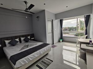 a bedroom with a bed and a large window at The Bypass Inn in Siliguri