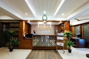 a lobby with a reception desk with a clock at Falnir Palace in Mangalore