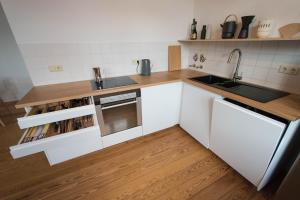 a kitchen with white cabinets and a sink at Modern design im klassischem Altbau in Weimar