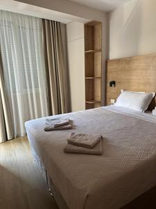 a bedroom with a bed with two towels on it at Apartmani Jedro in Rafailovici