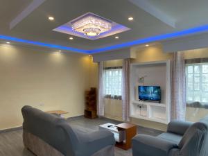 a living room with a couch and a tv at Brixton BnB in Naivasha