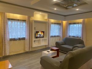 a living room with a couch and a tv at Brixton BnB in Naivasha