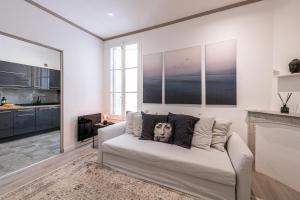 a living room with a white couch with a face pillow at Modern Apartment - Monaco border in Beausoleil