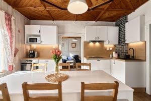 a kitchen with a table with a vase of flowers on it at Chalupa pod stromy in Kovářská