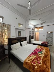 a bedroom with a bed with white sheets and flowers at Jagannath guest house in Udaipur