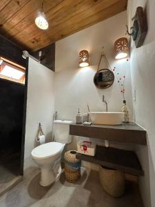a bathroom with a white toilet and a sink at Casa de praia exclusiva, pé na areia em Mogiquiçaba, Bahia in Belmonte