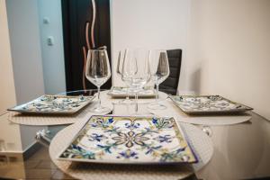 Una mesa con platos y copas de vino encima. en Melissa Home, en Bucarest 21 fotos más