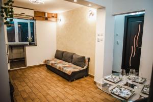 Una sala de estar con un sofá y dos mesas. en Melissa Home, en Bucarest