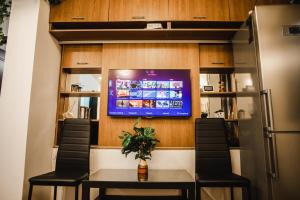 Habitación con TV, mesa y sillas. en Melissa Home, en Bucarest