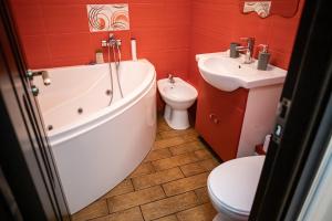 Un baño con bañera, inodoro y lavabo. en Melissa Home, en Bucarest