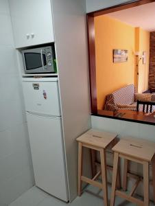 een magnetron bovenop een koelkast in een kamer bij Ajo surf house in Ajo