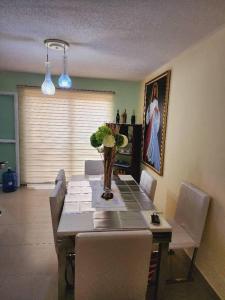 a dining room with a table with chairs and a painting at Apartmento Minutos Caracola Beach in Porlamar