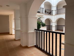 ein Flur eines Gebäudes mit weißen Wänden und einer Treppe in der Unterkunft El Valle Golf Resort in Baños y Mendigo