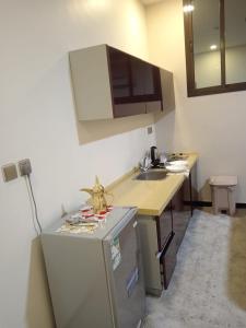a small kitchen with a sink and a refrigerator at فندق مرايا بارك in Najran