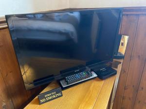 een tv bovenop een tafel met afstandsbedieningen bij West Royd in Robin Hood's Bay