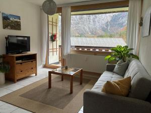 a living room with a couch and a large window at Ferienwohnung Held in Obertraun