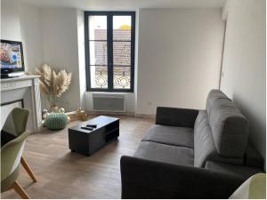 a living room with a couch and a window at chez Alain et Sylvie in Braine