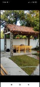 un banco de madera con un pabellón en un parque en Rusalka, en Kobuleti