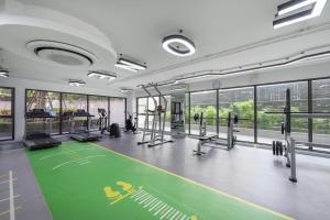 a gym with a green gym floor with machines at The One Chiang Mai 420 - Deluxe 1BDR Pool View near Central Festival in Chiang Mai