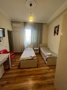 una habitación con dos camas y una mesa y un escritorio en Rusalka, en Kobuleti 12 fotos más