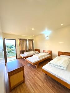 a room with three beds and a window at Sherpa Hills in Kathmandu