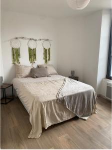 a white bedroom with a large bed with green curtains at chez Alain et Sylvie in Braine