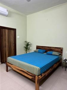 Un dormitorio con una cama grande con sábanas azules. en Veridian Villa, en Kānpur
