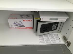 a microwave in a cabinet with a box and some papers at Studio face Mer - Village Naturiste - Cap d'Agde in Cap d'Agde