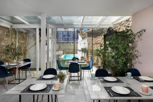 a restaurant with tables and chairs and a large window at Hotel Carmen Boutique in Baeza