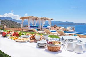 un tavolo bianco con sopra del cibo vicino all'oceano di Hotel Marsala a Kaş