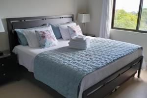 a white bedroom with a large bed with pillows at Seaview Paradise - Sleeps 3 - Pool - Parking in Negril +9 photos