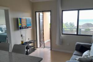 a living room with a couch and a sliding glass door at Seaview Paradise - Sleeps 3 - Pool - Parking in Negril
