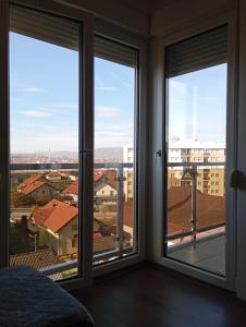 a room with windows with a view of a city at ALEXiS in Modriča