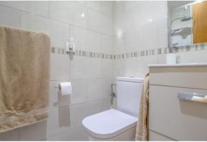 a white bathroom with a toilet and a sink at Costa Arenal 54 in Arenal d'en Castell