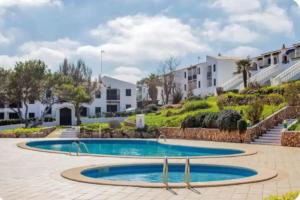 a swimming pool in a courtyard with houses at Costa Arenal 54 in Arenal d'en Castell