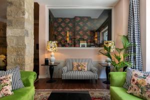 een woonkamer met 2 groene banken en een spiegel bij Hotel Carmen Boutique in Baeza