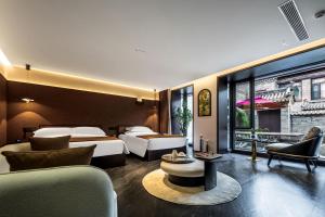 a hotel room with two beds and a couch at Yifan Shangyuan in Datong