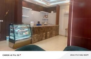 a man standing at a counter in a restaurant at رندة المدن للشقق المخدومة in Jazan