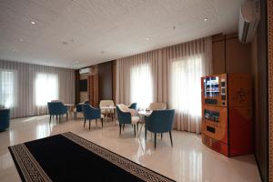 ein Esszimmer mit blauen Stühlen und einem Tisch und ein Zimmer mit Fenstern in der Unterkunft فندق ذا اس سكوير المطار The S Square Airport Hotel in Dschidda