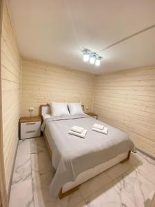 a bedroom with a bed with two towels on it at Іній in Vorokhta