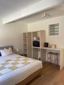a bedroom with a checkered bed and a desk at Archy's on the Lake in Burrill Lake