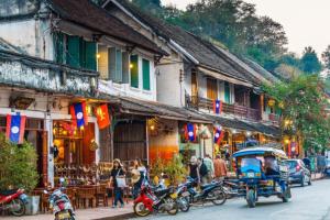 a group of motorcycles parked on a street next to buildings at We House River View Hotel And Travel in Luang Prabang