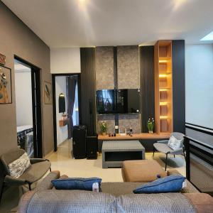 a bedroom with two beds and a living room at Villa Yo and By in Karangploso