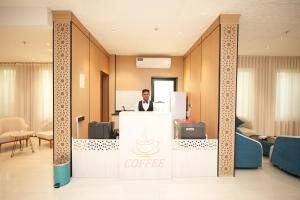 Ein Mann steht an einem Kaffeetresen in einem Büro. in der Unterkunft فندق ذا اس سكوير المطار The S Square Airport Hotel in Dschidda