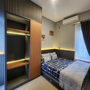 a small bedroom with a bed and a closet at Villa Yo and By in Karangploso