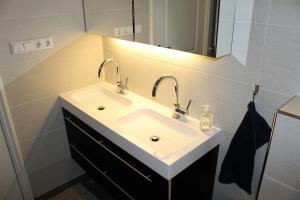 a bathroom with a white sink and a mirror at The Cozy Nest in Arnhem +8 photos