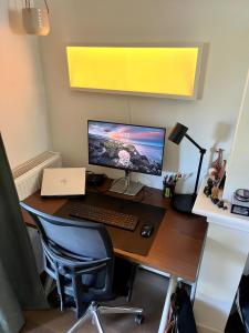 a desk with a computer monitor and a keyboard at The Cozy Nest in Arnhem