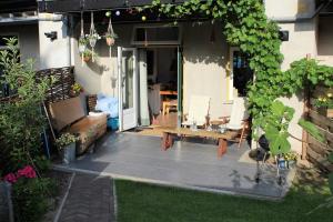 a patio with a bench and a table in front of a house at The Cozy Nest in Arnhem