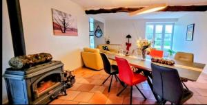 a living room with a fireplace and a table and chairs at La Colline Gersoise-Piscine-Sauna in La Sauvetat