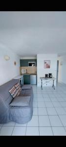 un salon avec un canapé et une table dans l'établissement Zenitude Corniche charmant studio cabine vue mer, à Sète